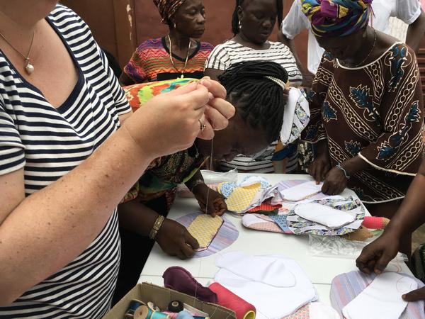 Women standing up as they learn to sew in Sierra Leone