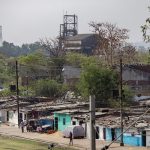 Photo of the shanty-town of Bhopal with the Union Carbide pesticide plant still towering in the background