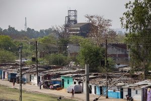 Photo of the shanty-town of Bhopal with the Union Carbide pesticide plant still towering in the background