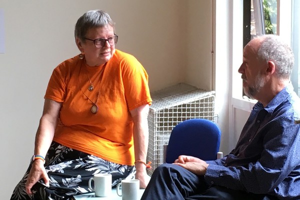 two people discussing a 'what can we do' meeting, over a cup of tea
